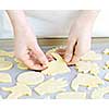 Chef placing cutout cookie dough shapes on tray for baking