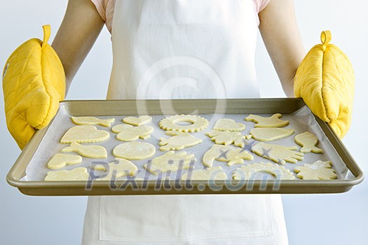 Woman holding a cookie tray with homemade cookies for baking