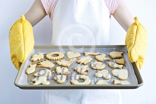 Woman holding fresh baked homemade shortbread cookies on cookie tray