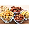 Almonds, cashews pistachio and pine nuts in glass bowls