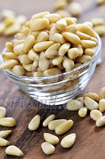 Glass bowl with big pile of pine nuts Glass bowl with big pile of pine nuts
