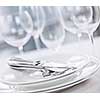 Elegant restaurant table setting with plates cutlery and stemware