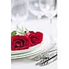 Romantic table setting for two with roses plates and cutlery