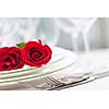 Romantic table setting for two with roses plates and cutlery