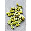 Several whole green cardamom seed pods on wooden background