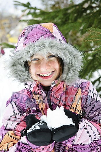 Portrait of happy teenage girl holding snow in gloves Portrait of happy teenage girl holding snow in gloves