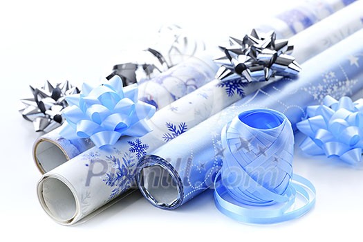 Rolls of Christmas wrapping paper with ribbons and bows