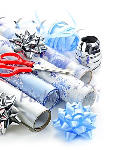 Rolls of Christmas wrapping paper with ribbons, bows and scissors Rolls of Christmas wrapping paper with ribbons, bows and scissors