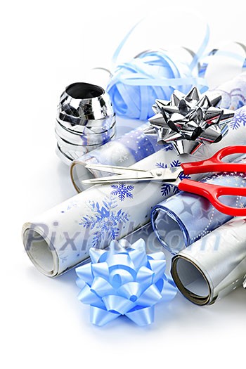 Rolls of Christmas wrapping paper with ribbons, bows and scissors Rolls of Christmas wrapping paper with ribbons, bows and scissors