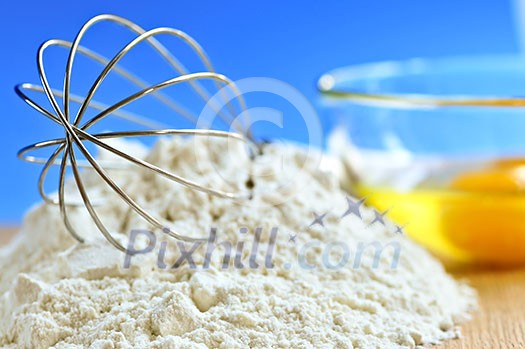 Flour, whisk and eggs in a bowl, baking ingredients Flour, whisk and eggs in a bowl, baking ingredients