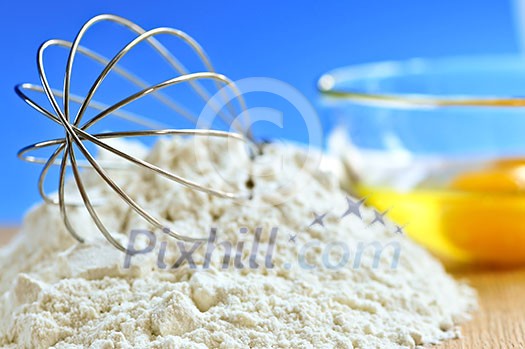 Flour, whisk and eggs in a bowl, baking ingredients