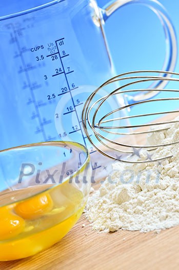 Flour, whisk and eggs in a bowl, baking ingredients Flour, whisk and eggs in a bowl, baking ingredients