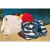 Summer beach bags on sand with towels and sunglasses