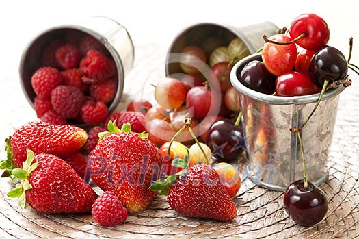 Assorted summer fruits and berries in metal pails