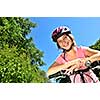 Portrait of a teenage girl on a bicycle in summer park outdoors