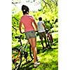 Teenage girl and her father with bicycles in summer park