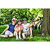 Family resting in summer park with bicycles