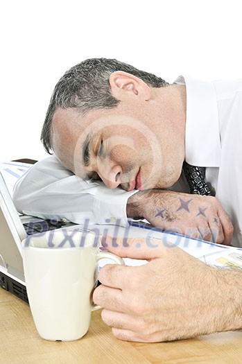 Tired businessman asleep at his desk isolated on white background