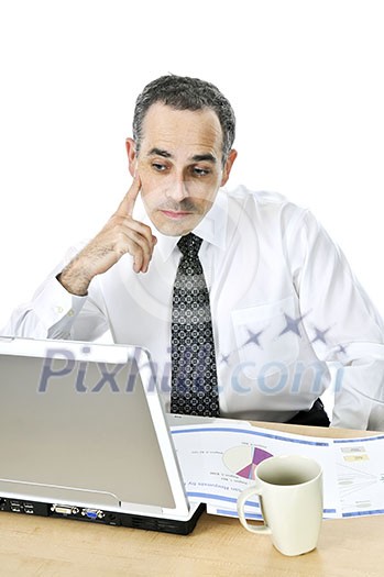 Thoughtful businessman sitting at his desk isolated on white background