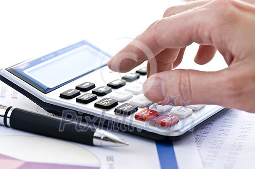 Typing  numbers for income tax return with pen and calculator