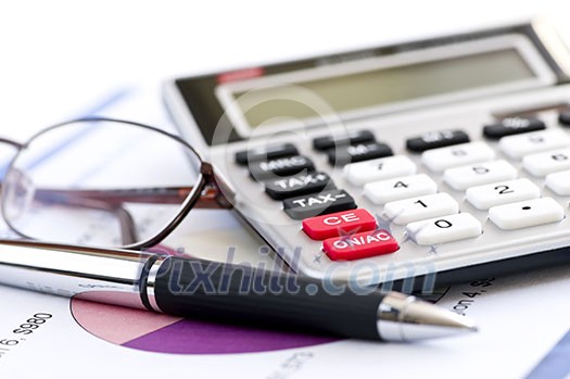 Calculating numbers for income tax return with glasses pen and calculator Calculating numbers for income tax return with glasses pen and calculator