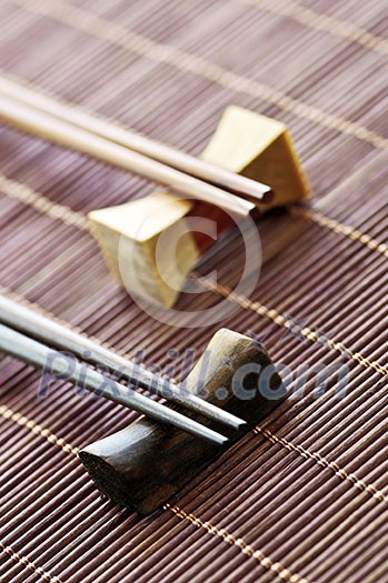 Two sets of wooden chopsticks on rests close up Two sets of wooden chopsticks on rests close up