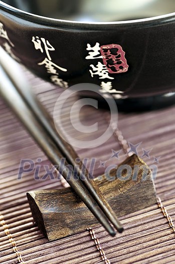 Asian rice bowl and wooden chopsticks on a rest close up Asian rice bowl and wooden chopsticks on a rest close up