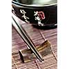 Asian rice bowl and wooden chopsticks on a rest close up