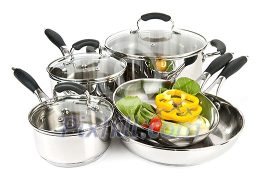 Stainless steel pots and pans isolated on white background with vegetables Stainless steel pots and pans isolated on white background with vegetables