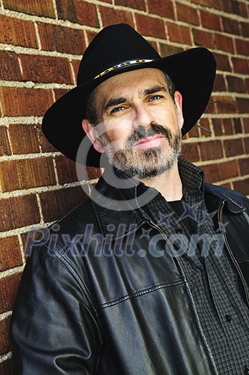 Man with beard in cowboy hat and leather jacket