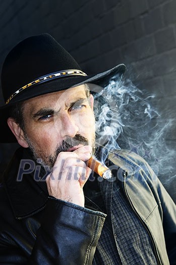 Man with beard in cowboy hat smoking cigar Man with beard in cowboy hat smoking cigar