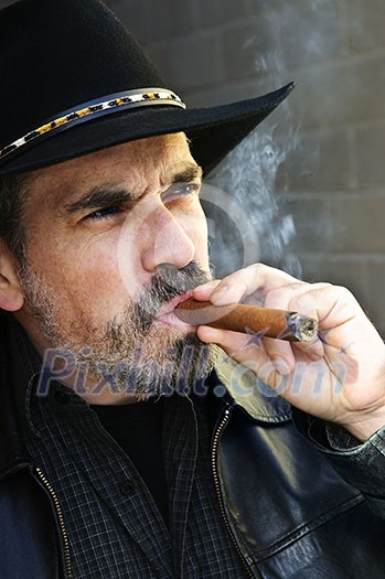 Man with beard in cowboy hat smoking cigar Man with beard in cowboy hat smoking cigar