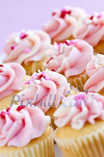 Lots of tasty cupcakes with icing and sprinkles Lots of tasty cupcakes with icing and sprinkles