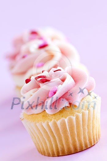 Row of tasty cupcakes with icing and sprinkles Row of tasty cupcakes with icing and sprinkles