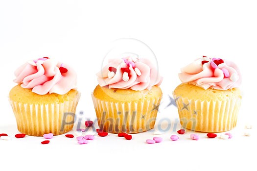 Row of tasty cupcakes with icing and sprinkles