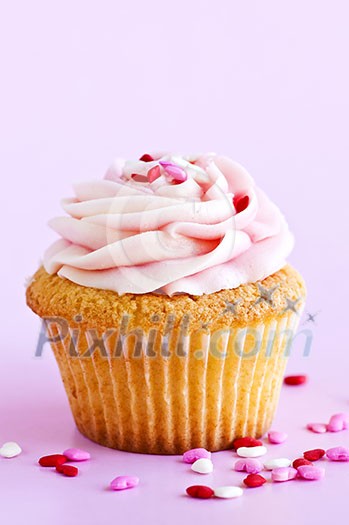 Single cupcake with pink icing and sprinkles