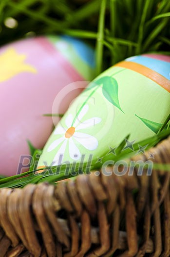 Easter eggs arrangement with green grass in a basket