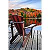 Wooden dock with chair on calm fall lake