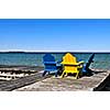 Painted wooden chairs on dock at a lake