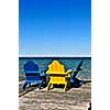 Painted wooden chairs on dock at a lake