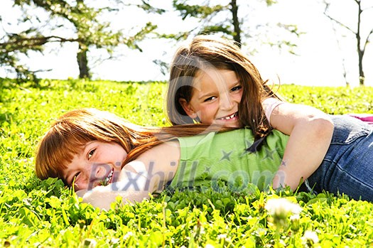 Portrait of happy girls playing on grass