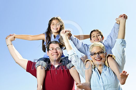 Happy family having fun giving shoulder rides Happy family having fun giving shoulder rides