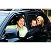 Happy young family sitting in black car looking out windows