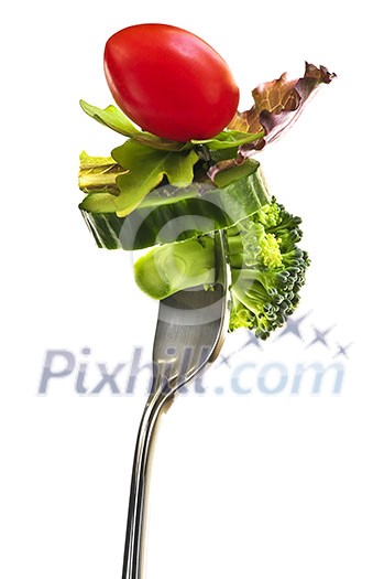 Fresh vegetables on a fork isolated on white background