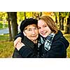 Teen granddaughter hugging grandmother in autumn park