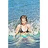 Young girl playing and splashing in a lake