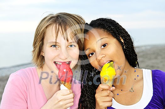 Portrait of two teenage girls eating ice cream cones