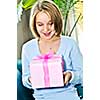 Teenage girl with braces holding wrapped present and smiling