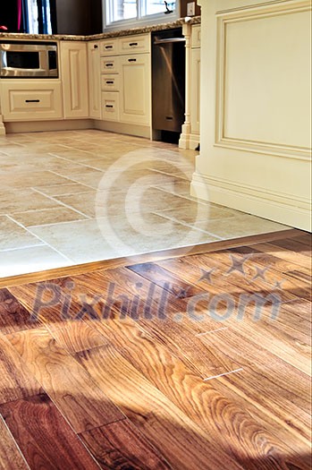 Hardwood and tile floor in residential home kitchen and dining room Hardwood and tile floor in residential home kitchen and dining room