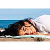 Portrait of beautiful smiling native american girl laying at beach